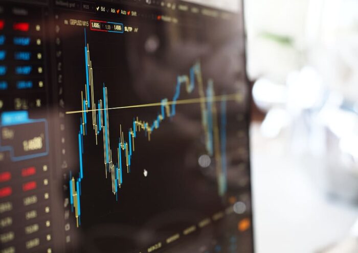 A trading screen displaying a fluctuating market chart with blue and yellow candlestick patterns.