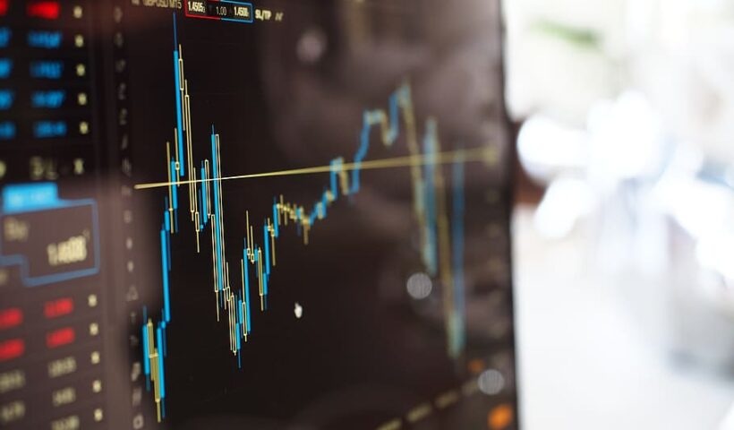 A trading screen displaying a fluctuating market chart with blue and yellow candlestick patterns.